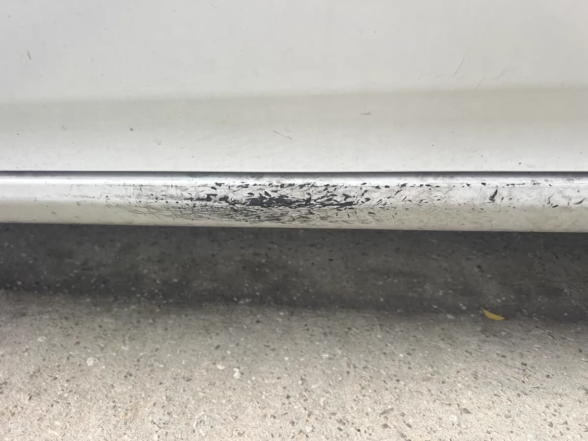Rocker panel scuffs and road grime — before